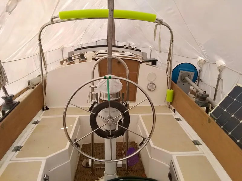 Slide: The Image of 1984 Cape Dory Cutter sailboat cockpit with steering wheel and covered deck. - 4