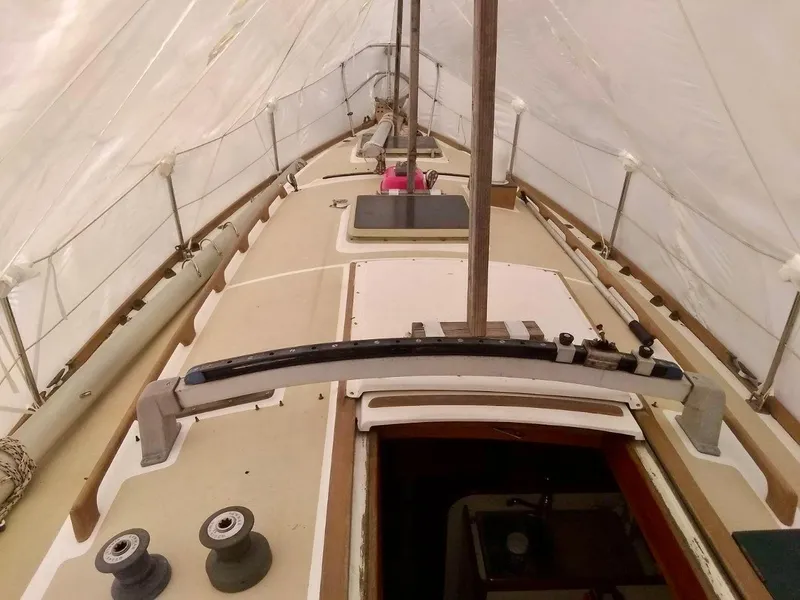 Slide: The Image of 1984 Cape Dory Cutter sailboat deck under cover, showcasing winches and hatch. - 5