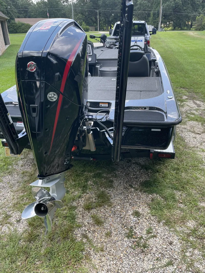 Slide: The Image of 2022 Caymas CX20 boat with powerful outboard motor, parked on grass. - 3