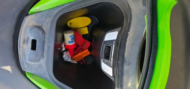 Slide: The Image of Storage compartment of a 2008 Kawasaki ULTRA250X with various small items inside. - 3