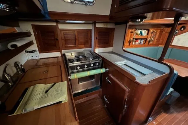 Slide: The Image of 1984 Mason 43 Cutter yacht kitchen with stove, wooden cabinets, and countertop. - 13