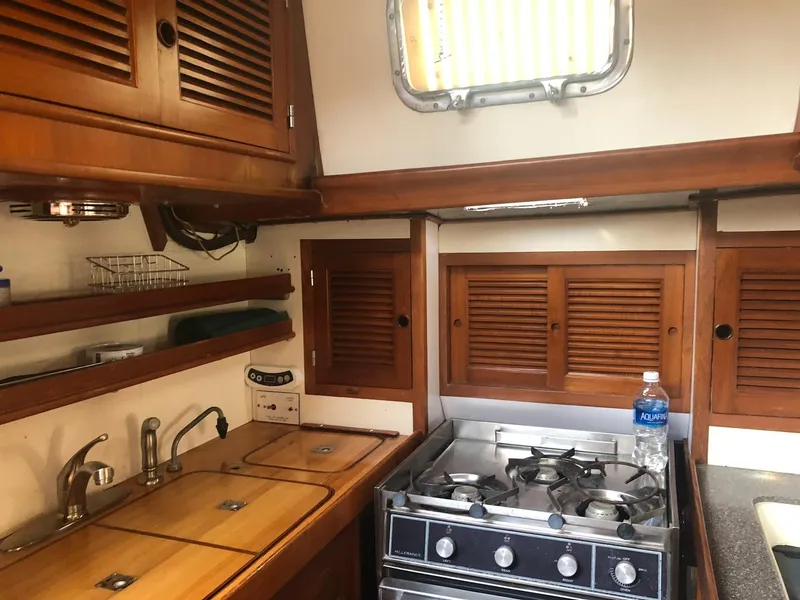 Slide: The Image of 1984 Mason 43 Cutter yacht kitchen with wooden cabinets and a stove. - 16
