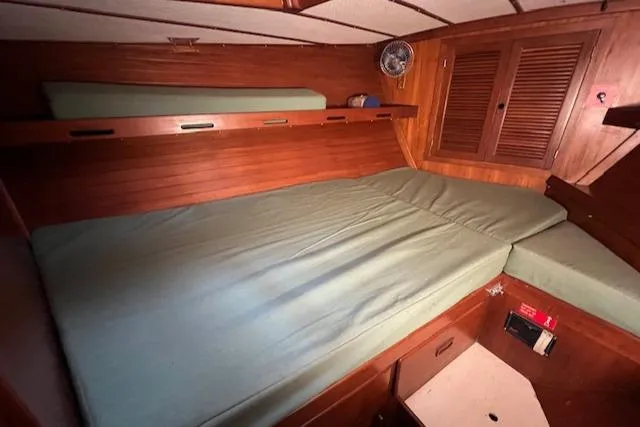 Slide: The Image of Interior cabin of 1984 Mason 43 Cutter with wooden finish and green bedding. - 22