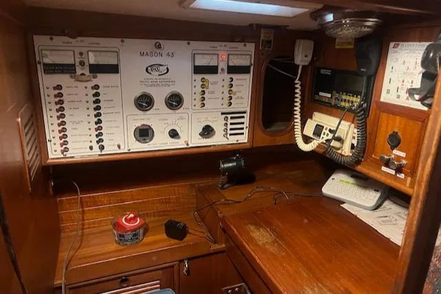Slide: The Image of Navigation station of a 1984 Mason 43 Cutter with control panels and communication equipment. - 23