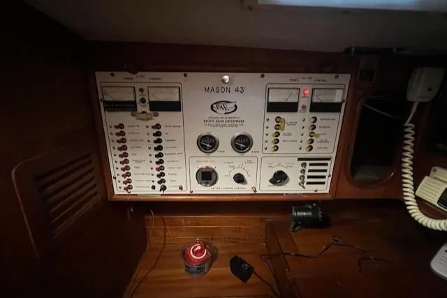 Slide: The Image of Control panel of a 1984 Mason 43 Cutter sailboat, featuring gauges and switches. - 24