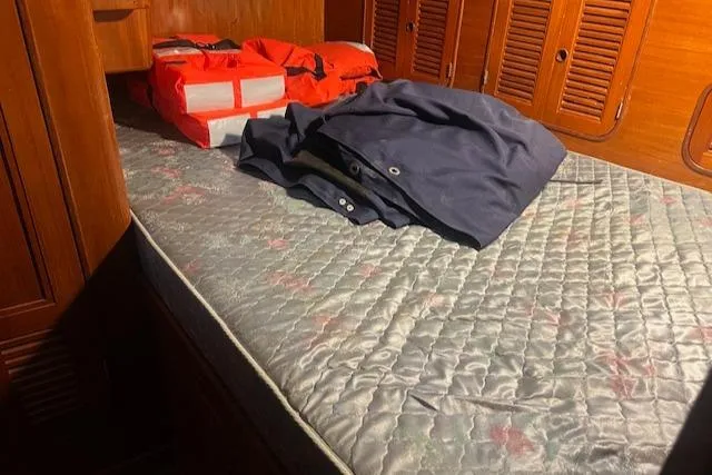 Slide: The Image of Cabin interior of 1984 Mason 43 Cutter with life jackets and folded clothing on bed. - 27