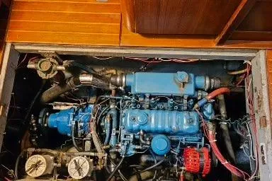 Slide: The Image of Engine compartment of a 1984 Mason 43 Cutter sailboat, featuring a blue marine engine. - 32