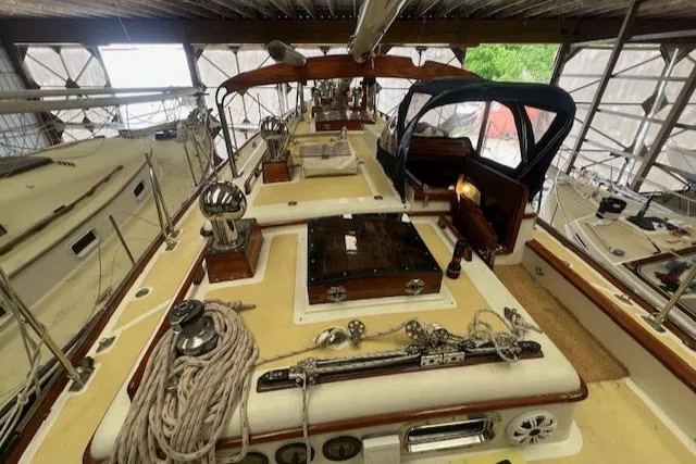 Slide: The Image of 1984 Mason 43 Cutter sailboat deck with ropes and equipment in a covered marina. - 33