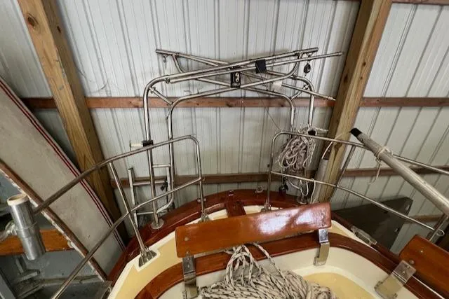 Slide: The Image of 1984 Mason 43 Cutter sailboat stern with stainless steel railings and ropes in a storage shed. - 37