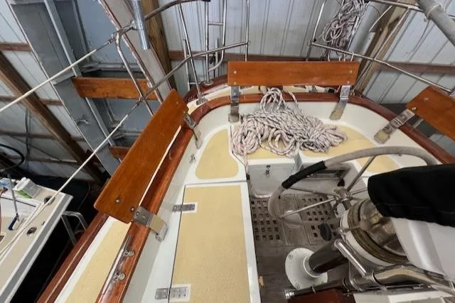 Slide: The Image of Cockpit of 1984 Mason 43 Cutter sailboat with wooden benches and coiled ropes. - 38