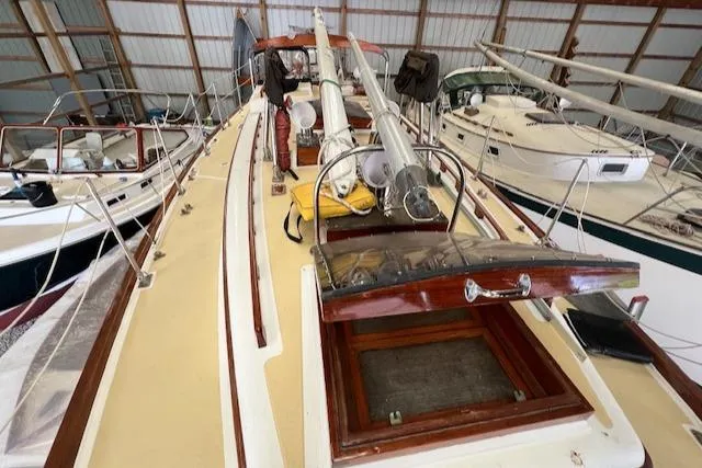 Slide: The Image of 1984 Mason 43 Cutter sailboat in storage, showcasing deck and cabin details. - 41