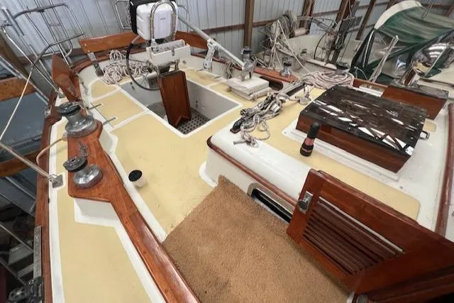 Slide: The Image of 1984 Mason 43 Cutter sailboat deck with wooden accents and nautical equipment. - 43