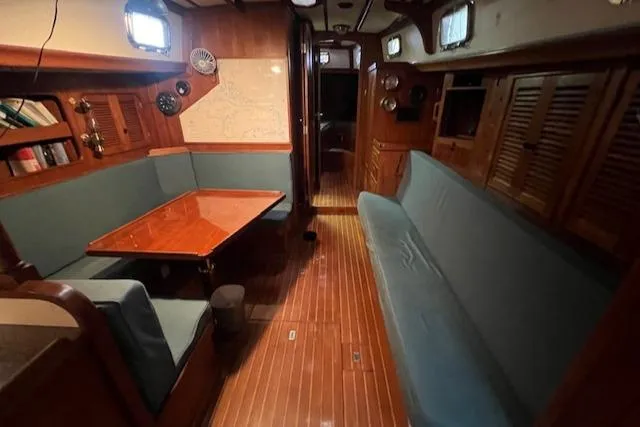 Slide: The Image of Interior of 1984 Mason 43 Cutter sailboat with wooden furnishings and seating area. - 6