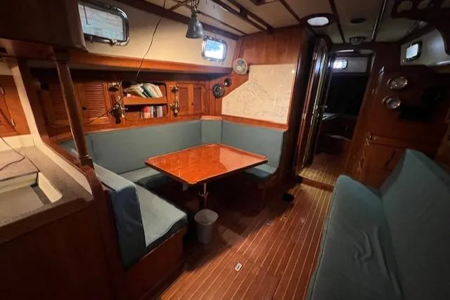 Slide: The Image of 1984 Mason 43 Cutter interior with wood finish, dining area, and cozy seating. - 7