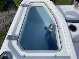 Slide: The Image of 2024 Yamaha Boats 255 FSH Sport E livewell with clear lid and blue interior. - 7