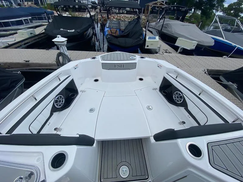 Slide: The Image of 2024 Yamaha Boats 255 FSH Sport E, spacious deck, docked among other boats. - 8