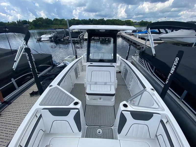 Slide: The Image of 2024 Yamaha Boats 255 FSH Sport E, docked, showcasing spacious seating and sleek design. - 9