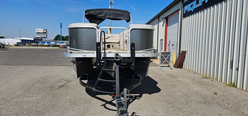 Slide: The Image of 2017 G3 Sun Catcher V322C pontoon boat on trailer, parked outside a warehouse. - 2