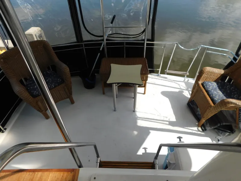 Slide: The Image of 1985 Carver 3607 Aft Cabin boat deck with wicker chairs and table. - 11