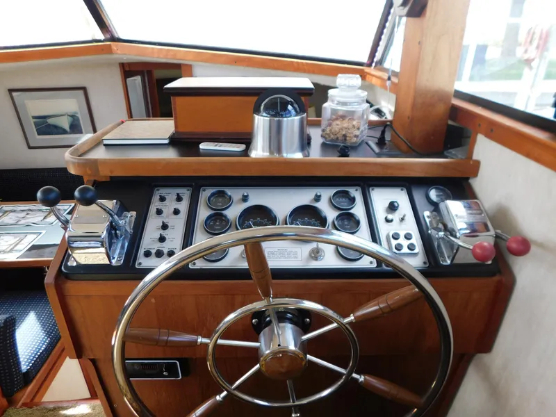 Slide: The Image of 1985 Carver 3607 Aft Cabin helm with wooden wheel and control panel. - 15