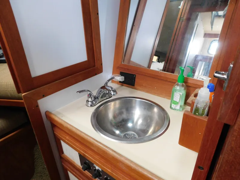 Slide: The Image of 1985 Carver 3607 Aft Cabin bathroom sink with mirror and toiletries. - 20