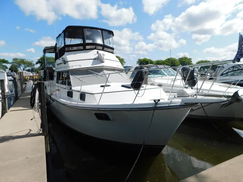 Slide: The Image of 1985 Carver 3607 Aft Cabin yacht docked at marina under blue sky. - 3