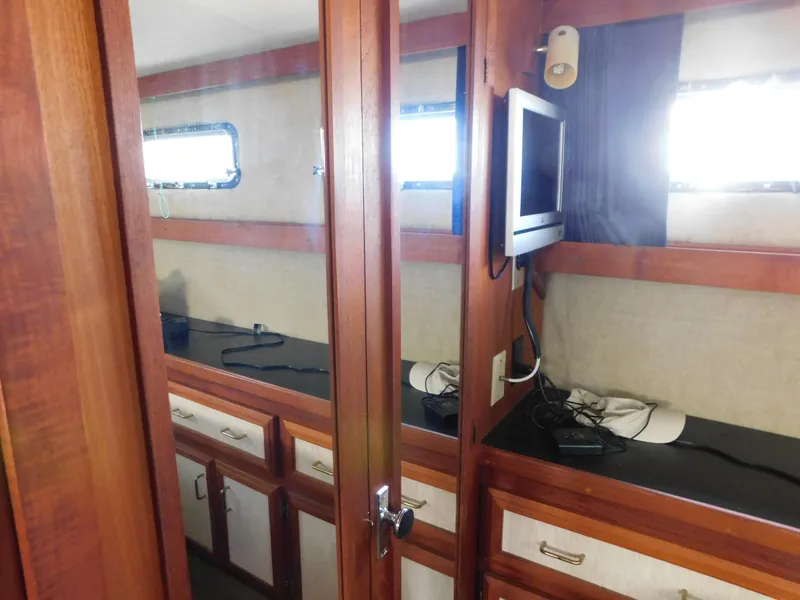 Slide: The Image of 1985 Carver 3607 Aft Cabin interior with wood cabinetry and mounted TV. - 30