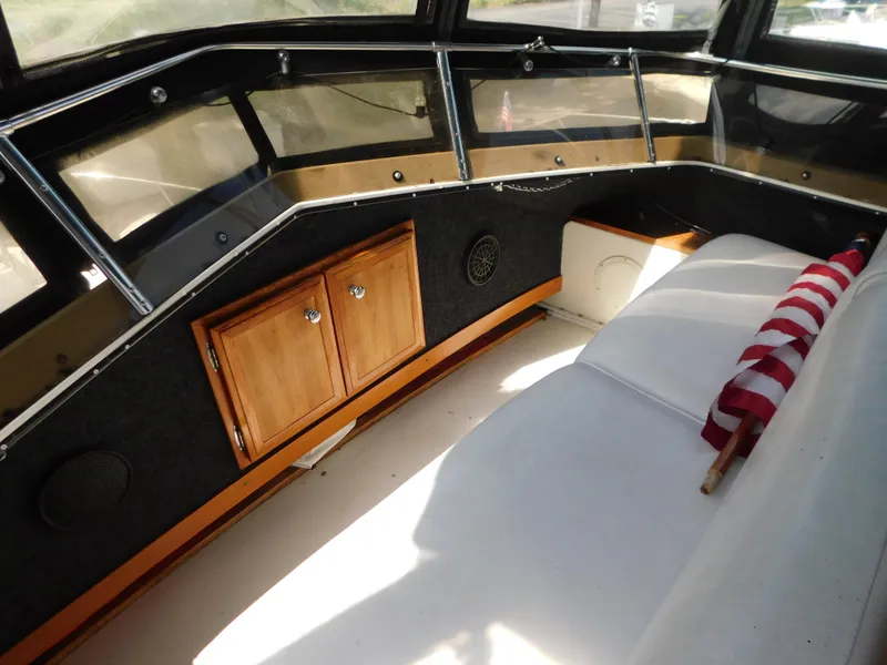 Slide: The Image of 1985 Carver 3607 Aft Cabin interior with seating, wooden cabinets, and American flag detail. - 9