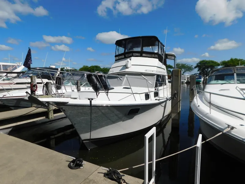 The Image of 1985 Carver 3607 Aft Cabin yacht docked at marina under blue sky. - 1