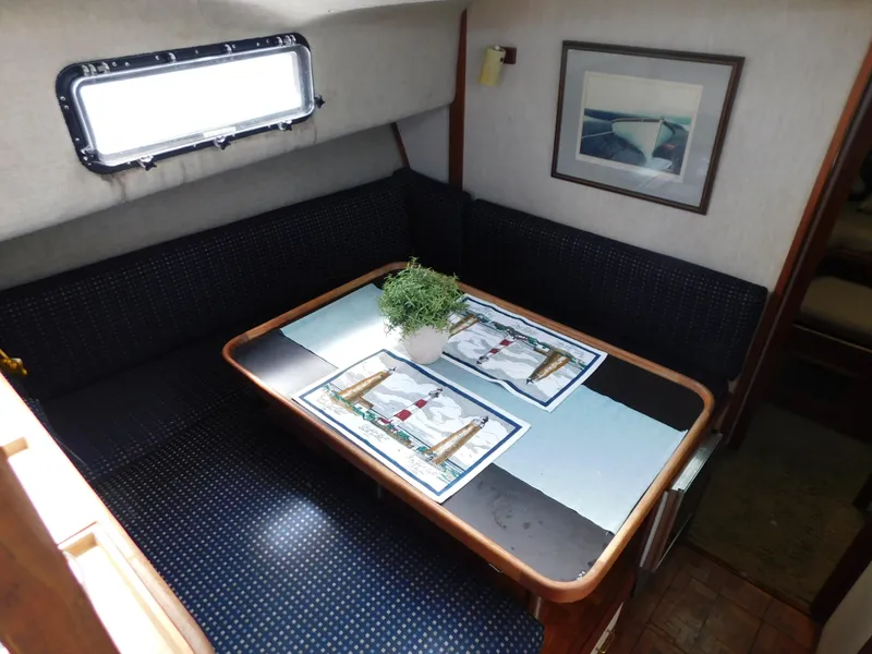 Slide: The Image of 1985 Carver 3607 Aft Cabin interior dining area with table, seating, and window. - 16