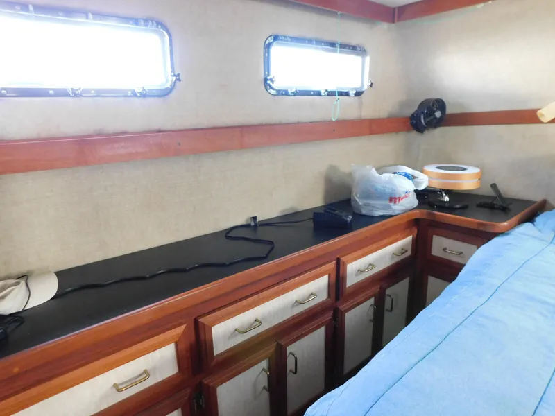 Slide: The Image of Interior of 1985 Carver 3607 Aft Cabin with storage cabinets and porthole windows. - 26