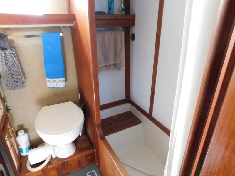 Slide: The Image of 1985 Carver 3607 Aft Cabin bathroom with toilet, shower, and wooden accents. - 28