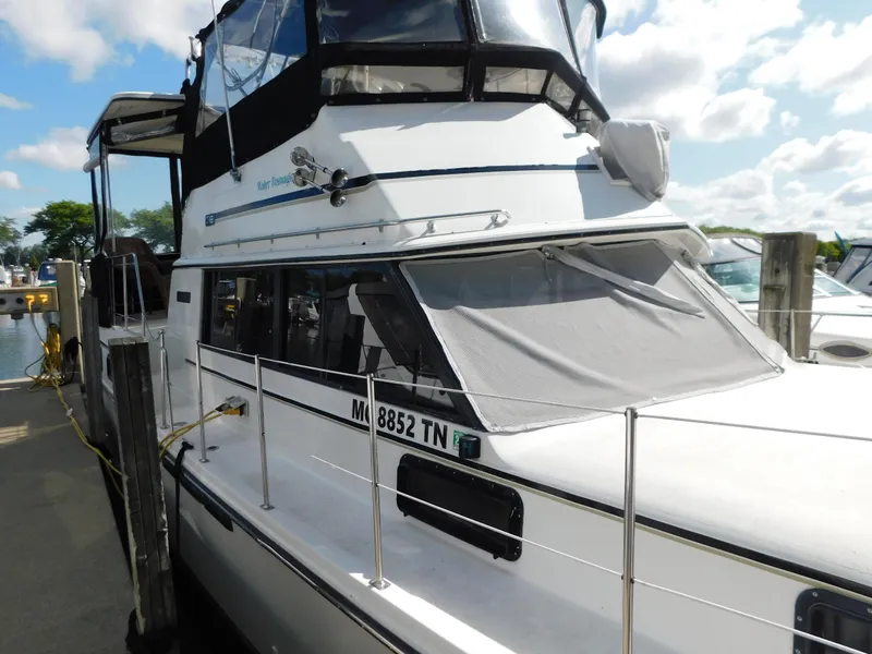 Slide: The Image of 1985 Carver 3607 Aft Cabin boat docked, featuring white exterior and covered windows. - 4
