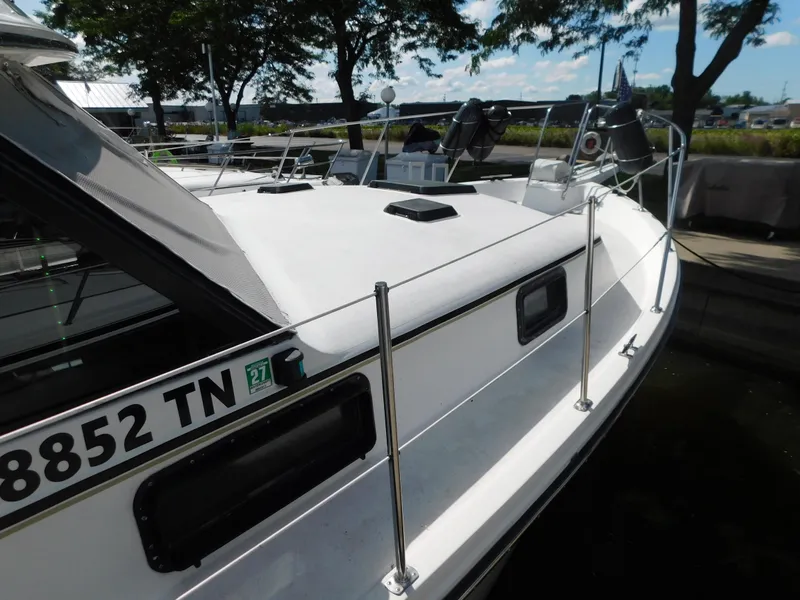 Slide: The Image of 1985 Carver 3607 Aft Cabin boat docked, featuring sleek white deck and railing. - 5