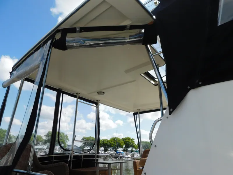Slide: The Image of 1985 Carver 3607 Aft Cabin boat with covered deck and marina view. - 6