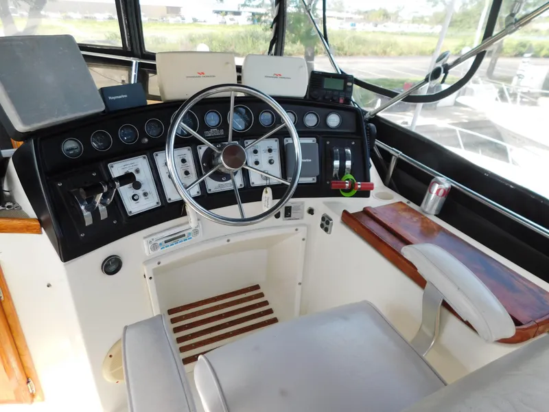 Slide: The Image of 1985 Carver 3607 Aft Cabin helm with steering wheel, gauges, and controls. - 8