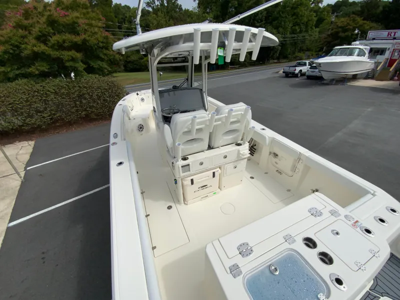 Slide: The Image of 2025 Cobia 265 Center Console Open boat, spacious deck, modern design, parked outdoors. - 10