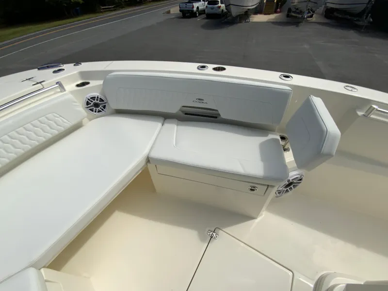 Slide: The Image of 2025 Cobia 265 Center Console Open boat interior with white seating and speakers. - 28