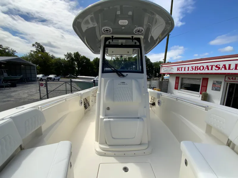 Slide: The Image of 2025 Cobia 265 Center Console Open boat at dealership, showcasing spacious deck and helm. - 34