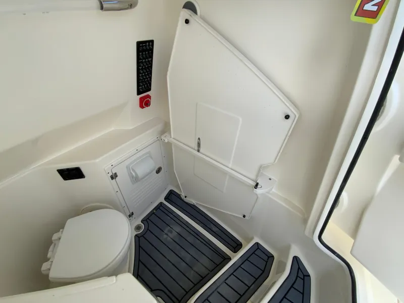 Slide: The Image of 2025 Cobia 265 Center Console Open boat interior with toilet and storage compartment. - 38
