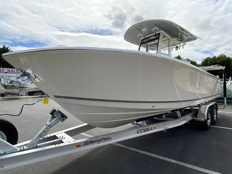 Slide: The Image of 2025 Cobia 265 Center Console Open boat on trailer, parked outdoors. - 4