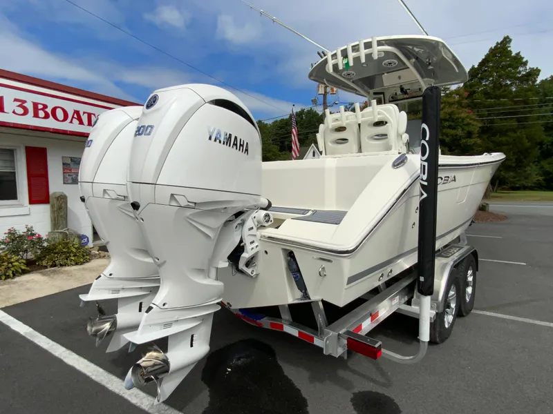 Slide: The Image of 2025 Cobia 265 Center Console Open boat with twin Yamaha engines on a trailer. - 9