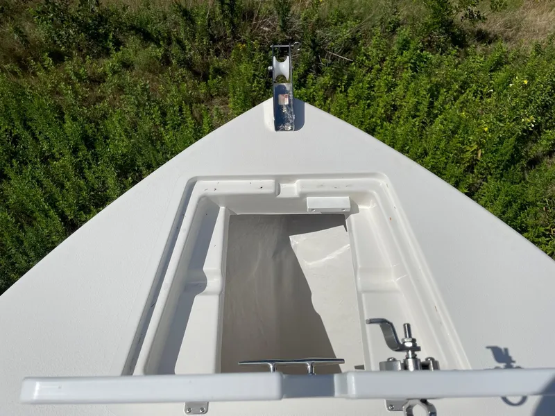 Slide: The Image of 2025 Defiance 240 Catalina boat bow with anchor locker, surrounded by greenery. - 11