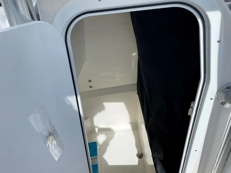 Slide: The Image of Interior cabin of 2025 Defiance 240 Catalina boat, featuring a compact, white space. - 12