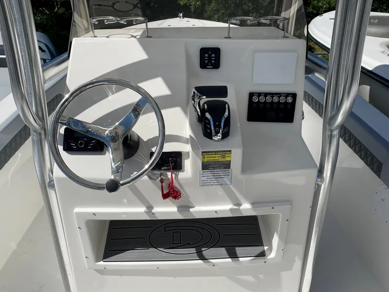 Slide: The Image of Defiance 240 Catalina 2025 boat console with steering wheel and controls. - 3