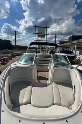 Slide: The Image of 2002 Chaparral 220 SSi boat with white seating, docked under a cloudy sky. - 10