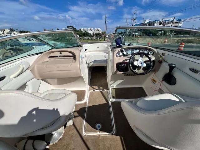 Slide: The Image of 2002 Chaparral 220 SSi boat interior with steering wheel and seating under blue sky. - 4