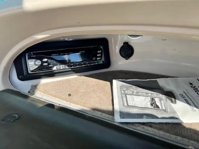 Slide: The Image of 2002 Chaparral 220 SSi boat stereo system with manual on carpeted surface. - 7