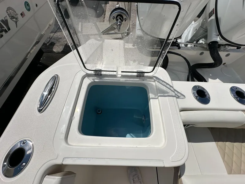 Slide: The Image of Bulls Bay 255 CC 2025 boat livewell with open lid and cup holders. - 11