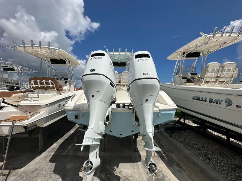 Slide: The Image of 2025 Bulls Bay 255 CC boat with dual outboard motors under a clear blue sky. - 3